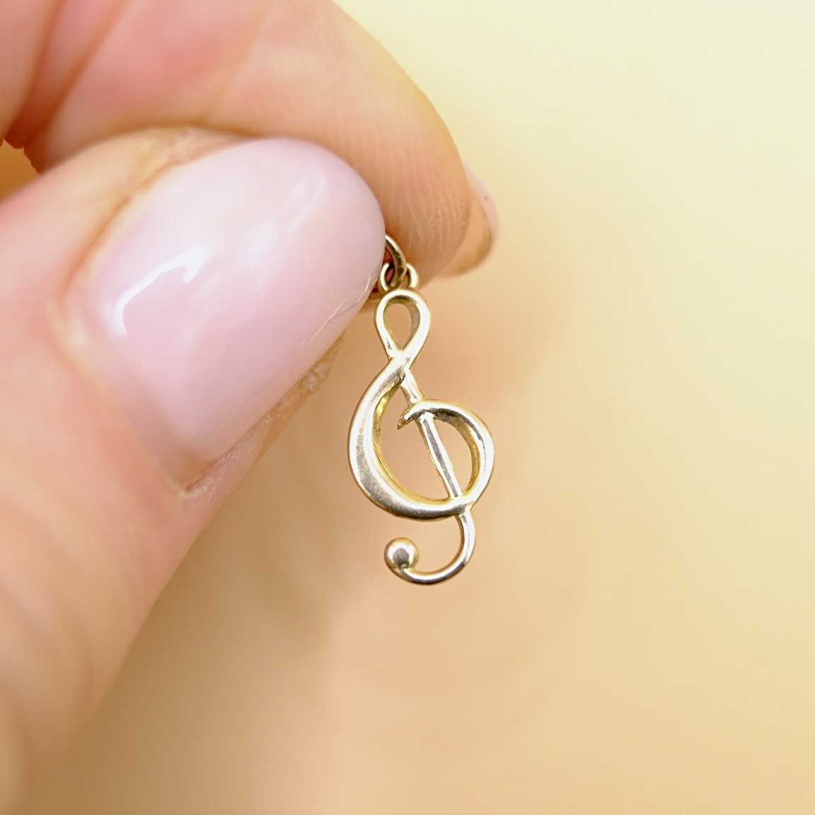 BVL999-9ct-treble-clef-charm-held.jpg