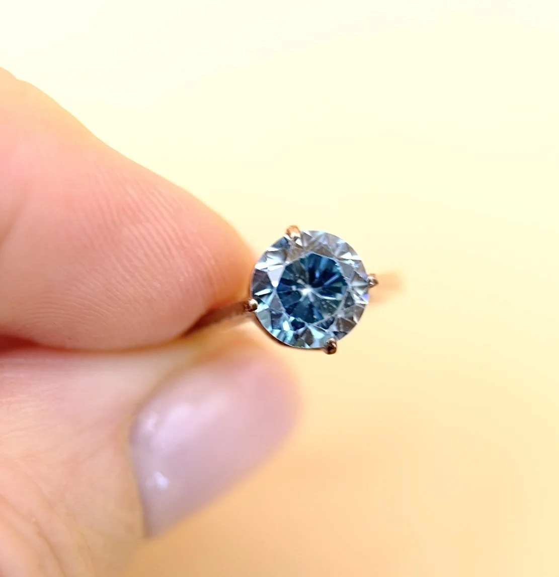 BVL1055-blue-zircon-solitaire-ring-held.jpg
