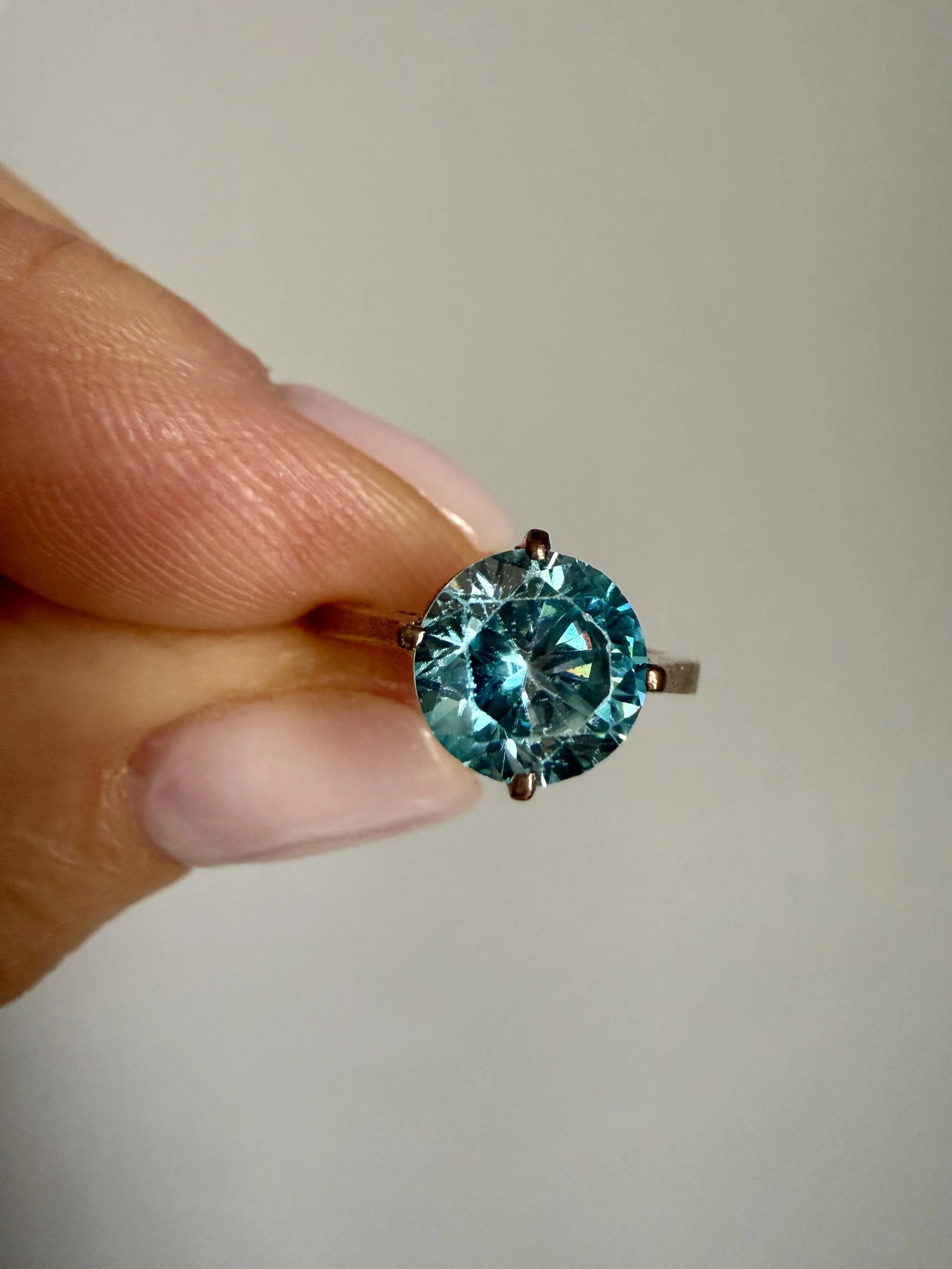 BVL1055-blue-zircon-solitaire-ring-held2.jpg