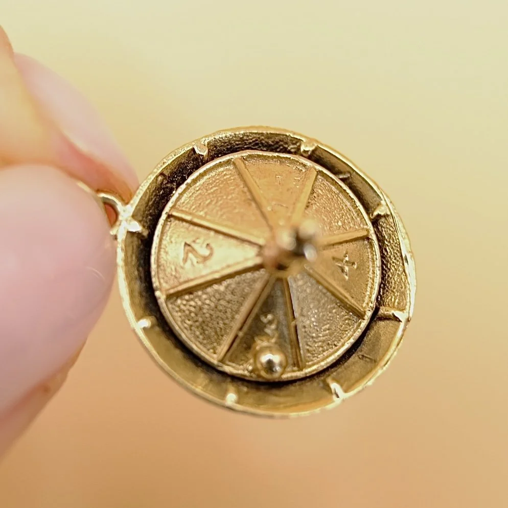 BVL1127-gold-roulette-wheel-pendant-held.jpg