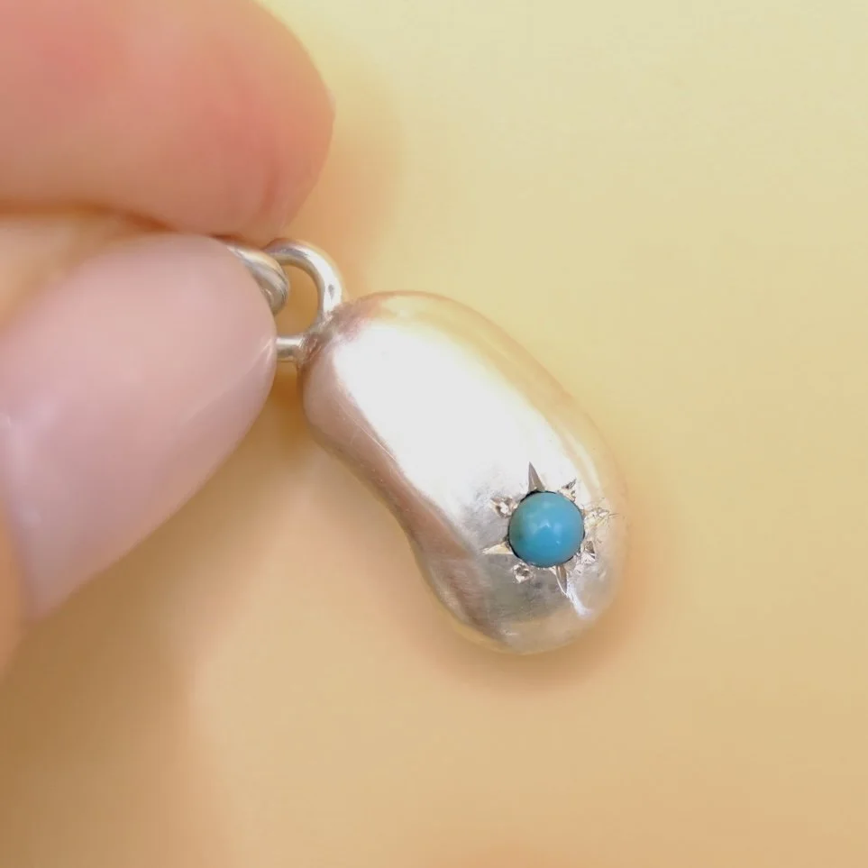 BVL1150-silver-turquoise-bean-charm-held.jpg