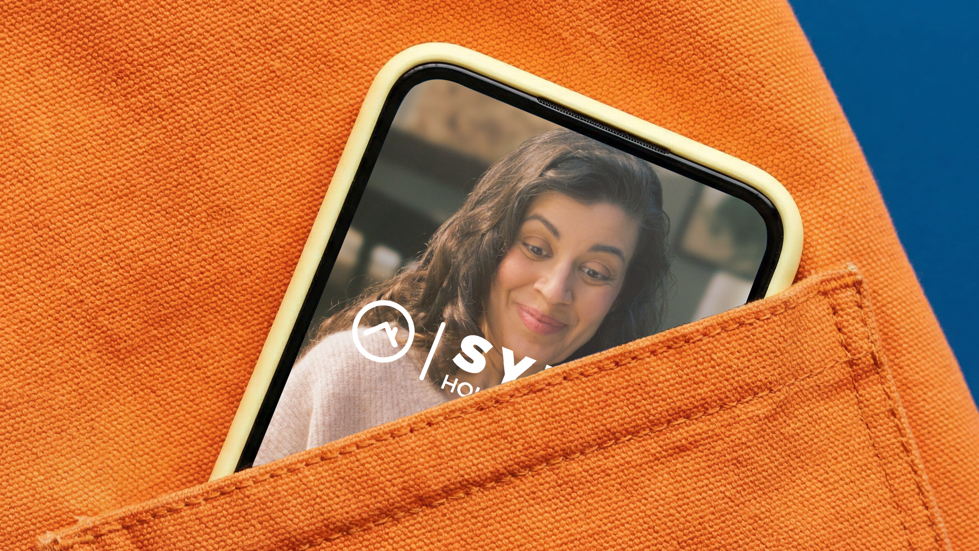Smartphone with a woman's face on the screen, inside an orange pocket.