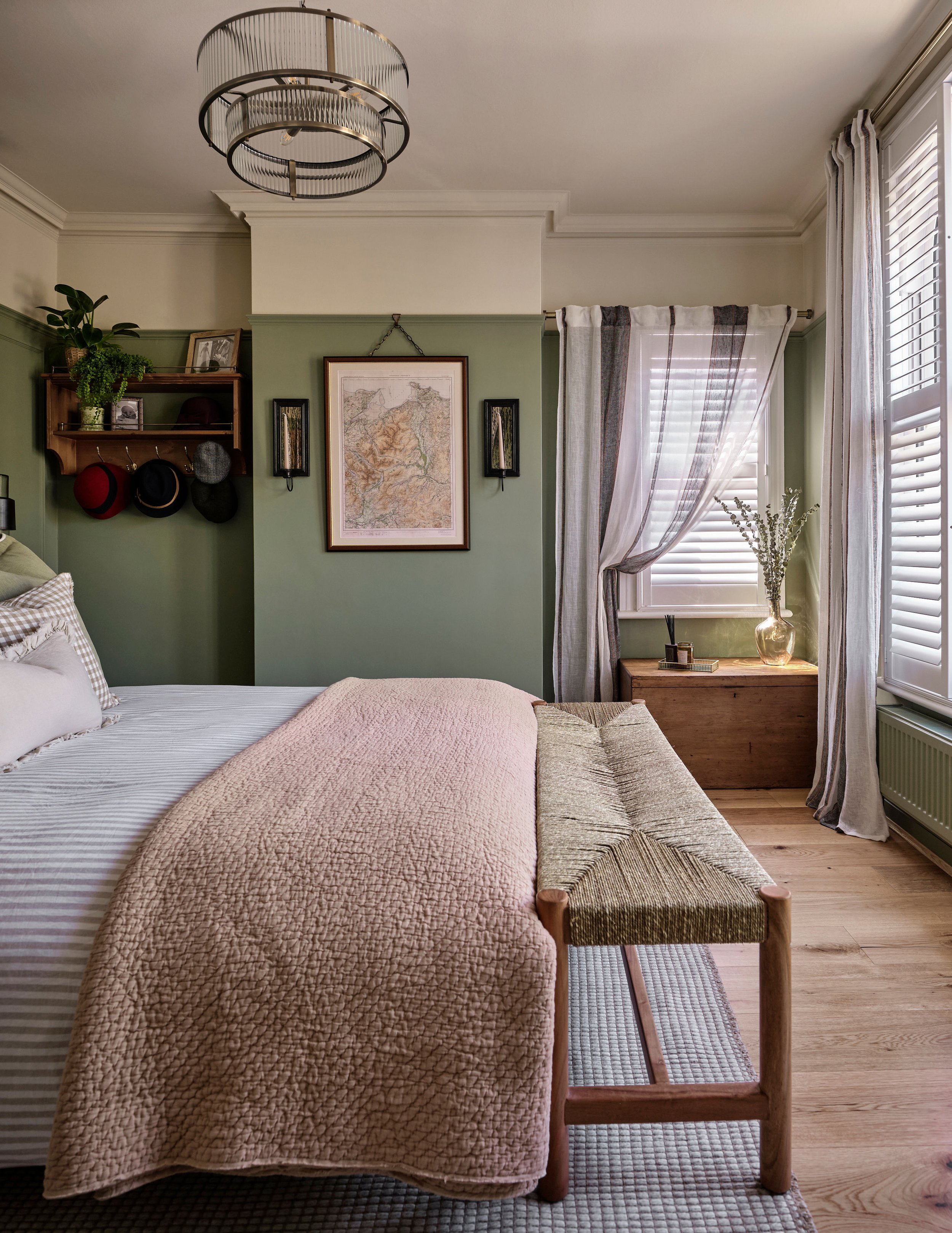 A layered bedroom with soft tones of green and apricot creates a calm nature-inspired bedroom to relax in