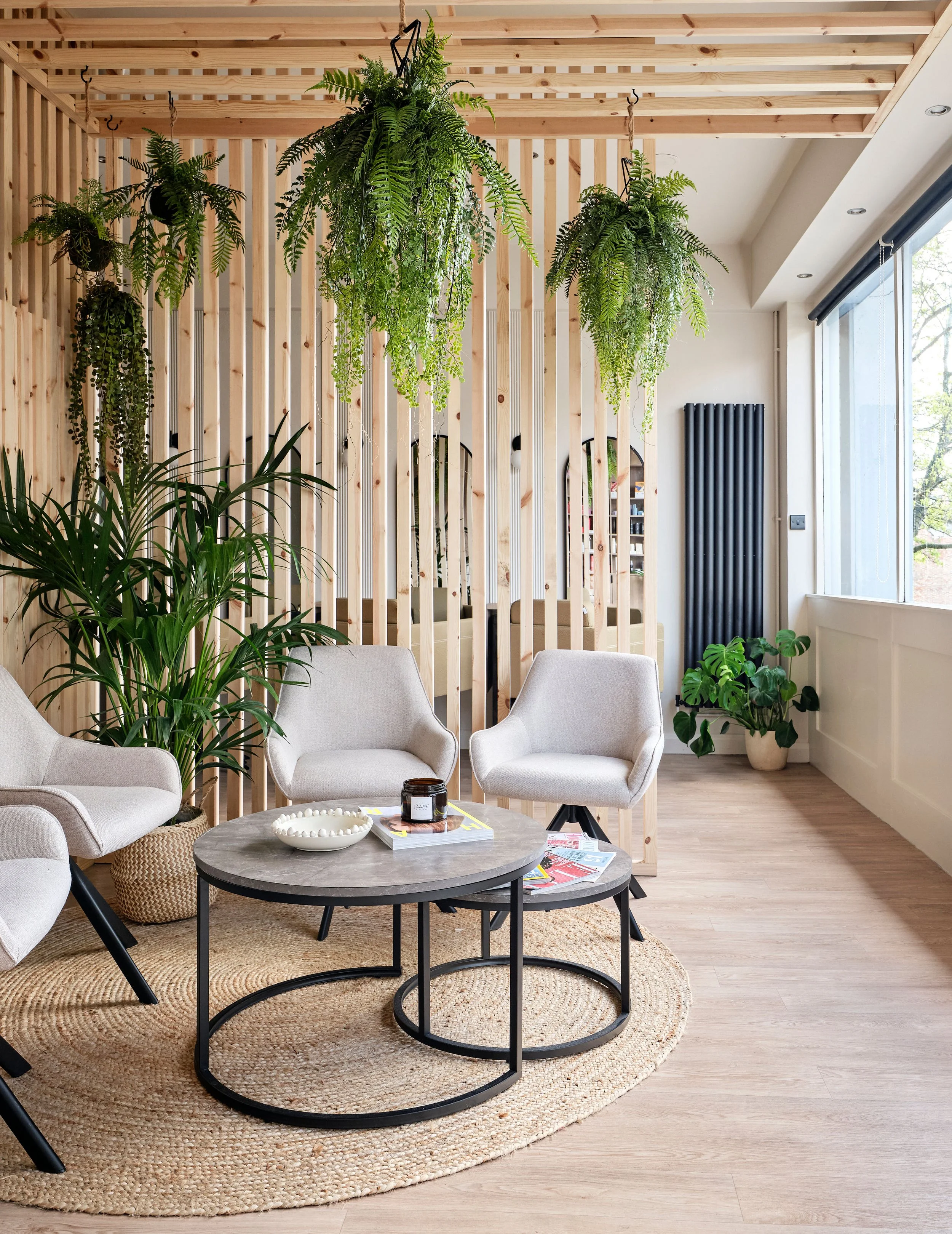 Airy waiting airy in modern calming hair salon with panelled dividing walls to zone area