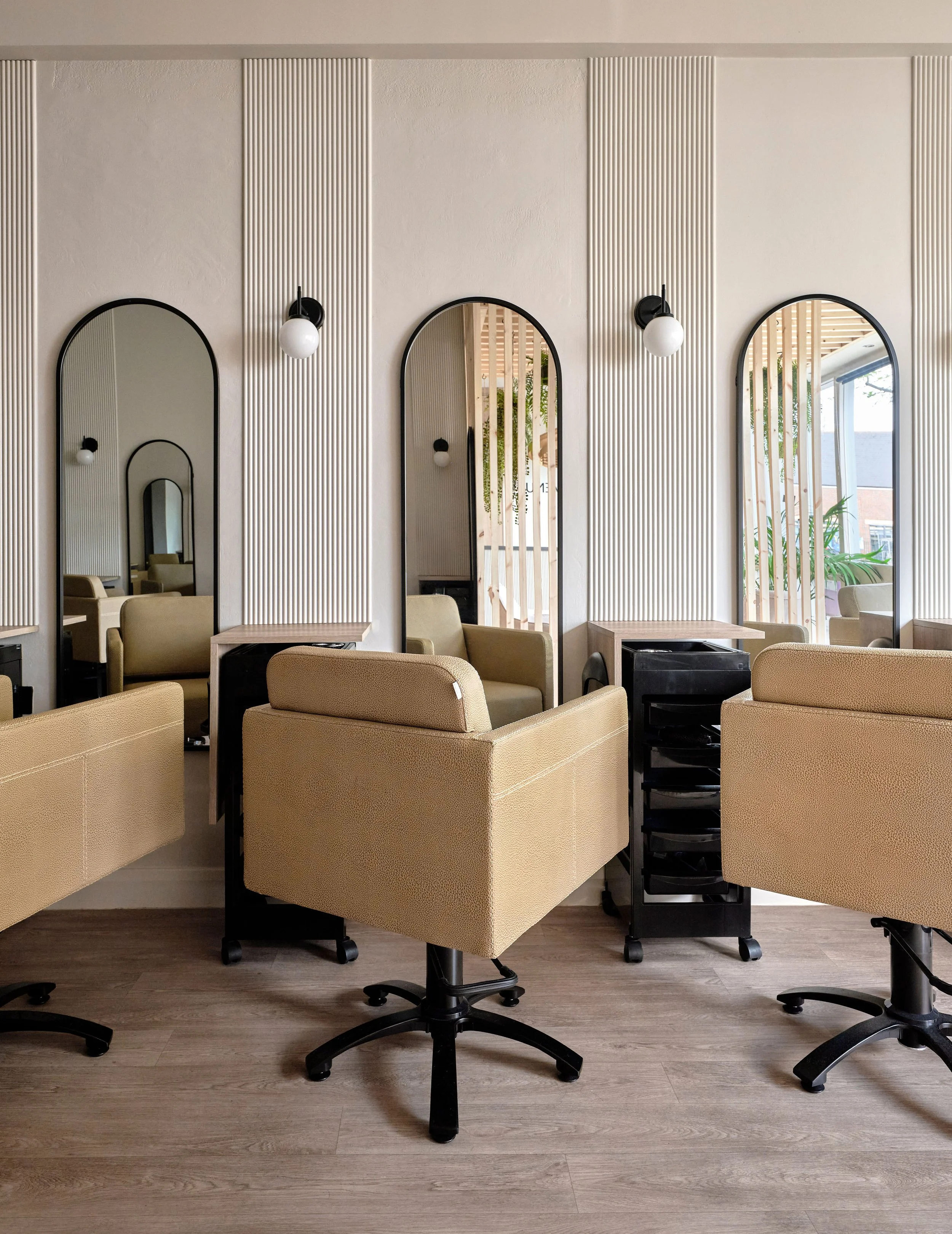 Taupe salon styling chairs and black accents in newly designed modern hair salon in Bedford