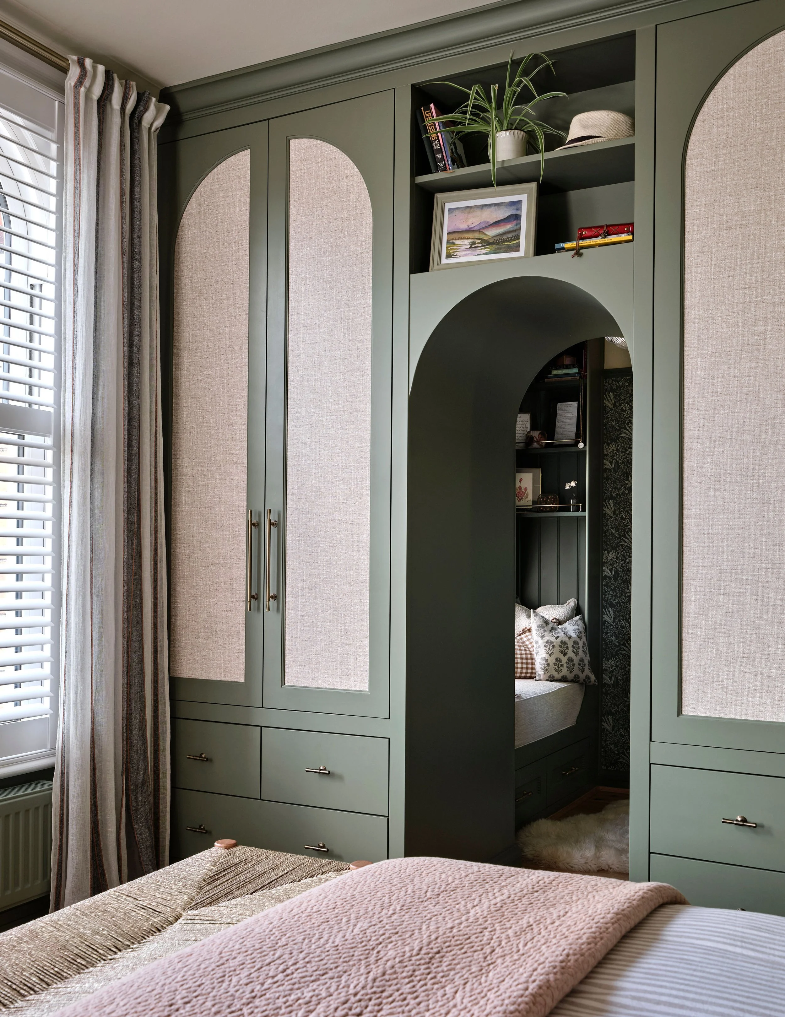 Arched wardrobe panels mirror the victorian arched windows in the room and the hessian inserts add dimension to the design with a beautiful contrast to the green tones
