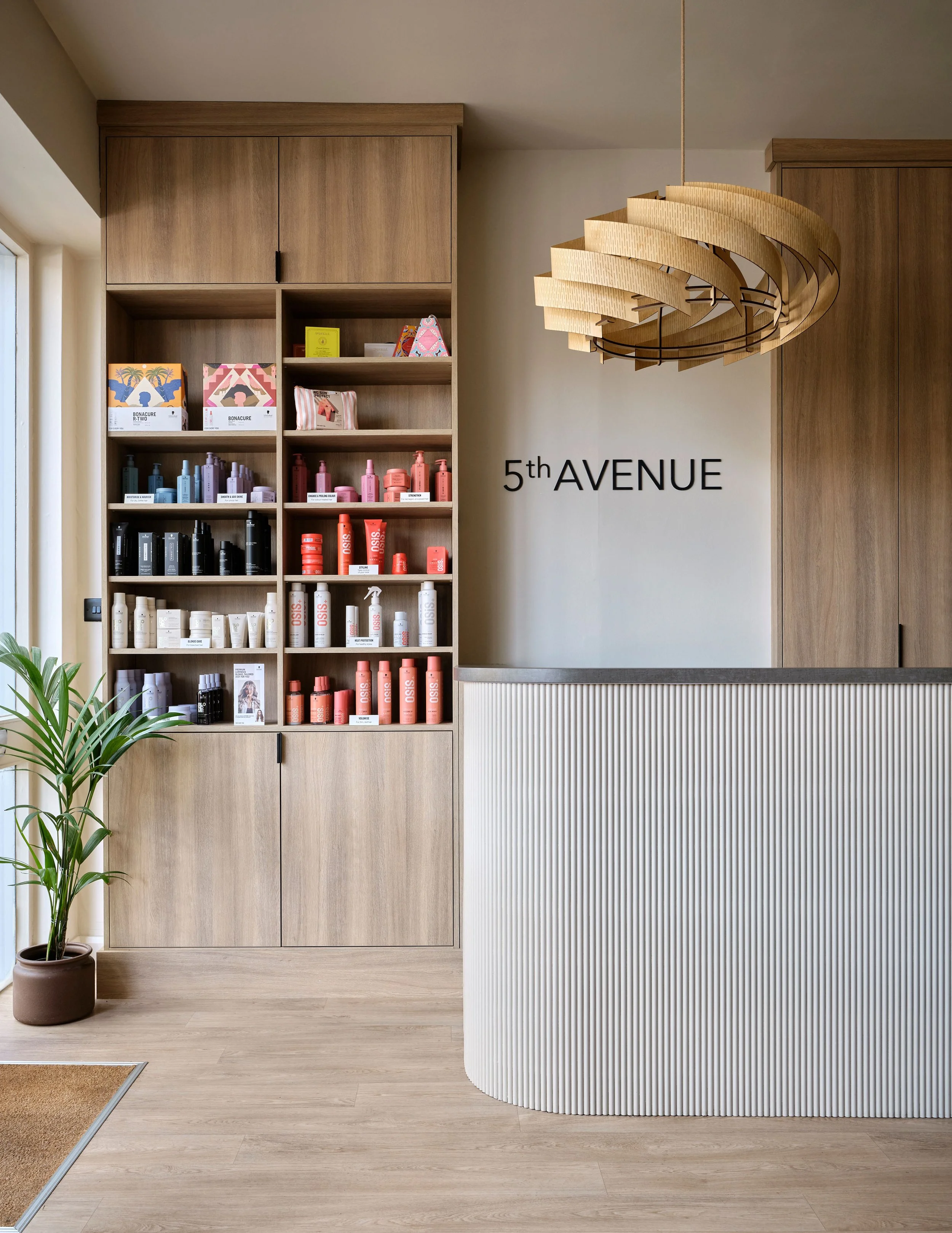 Reception desk in contemporary hair salon with panelled accents and neutral taupe tones