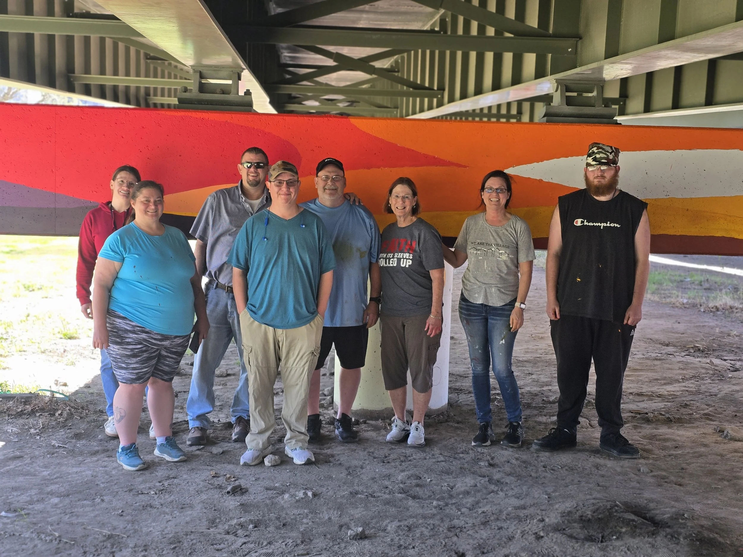 TRM group standing before a mural.