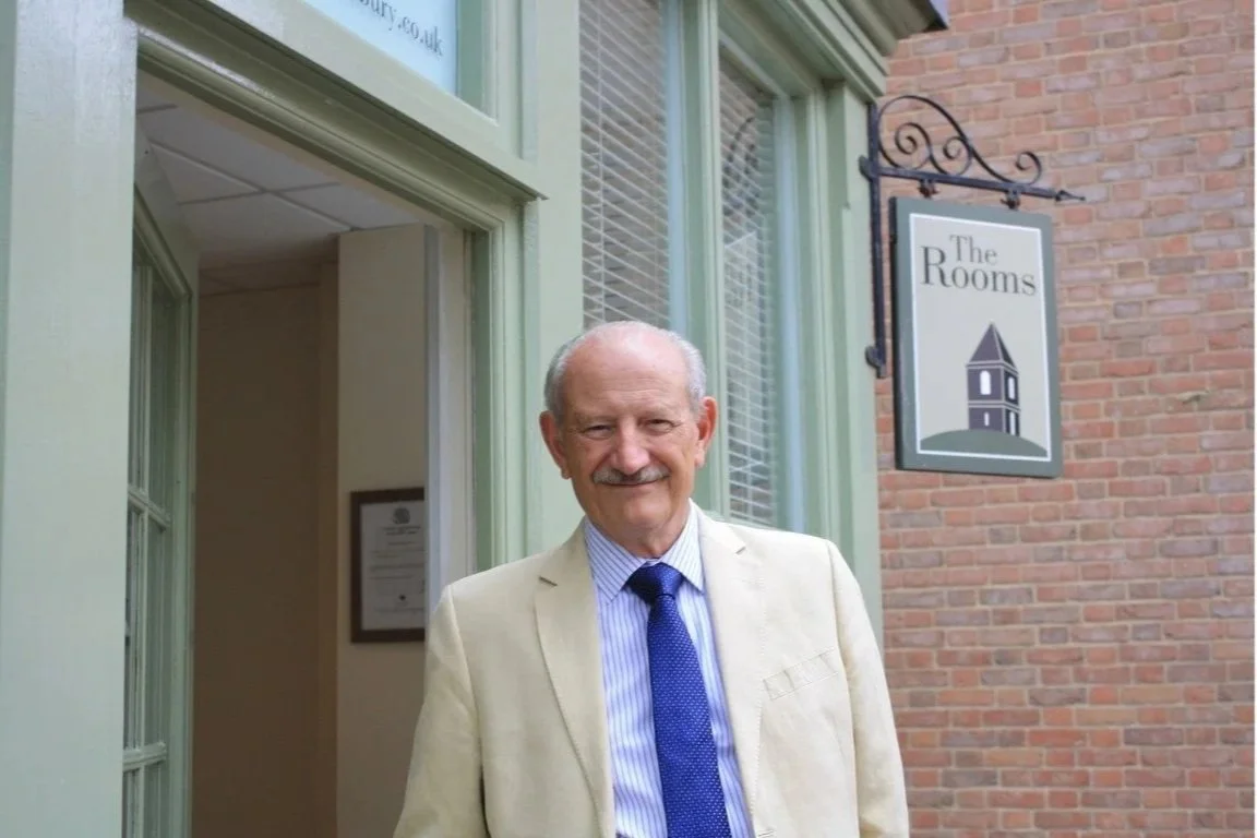 Marcel Wadman, podiatrist, standing outside a building with a sign that reads 'The Rooms'