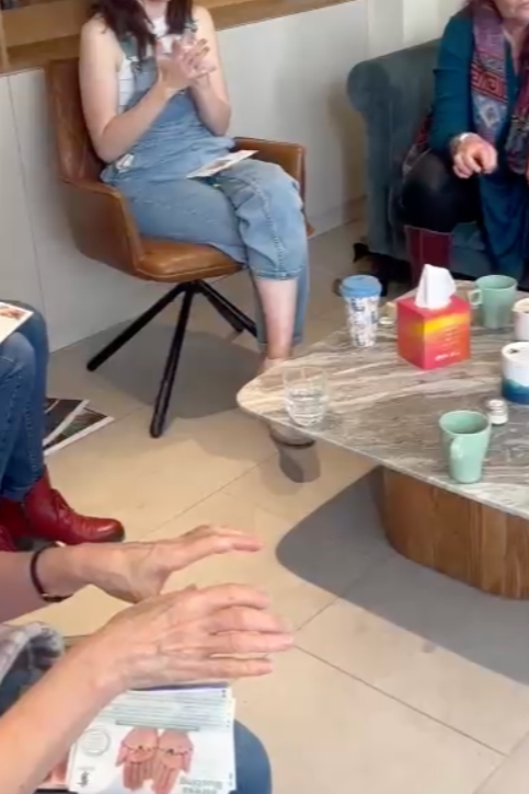 Hand reflexology workshop with Dr Carole Deighton, participants following tutorial on hand pressure points