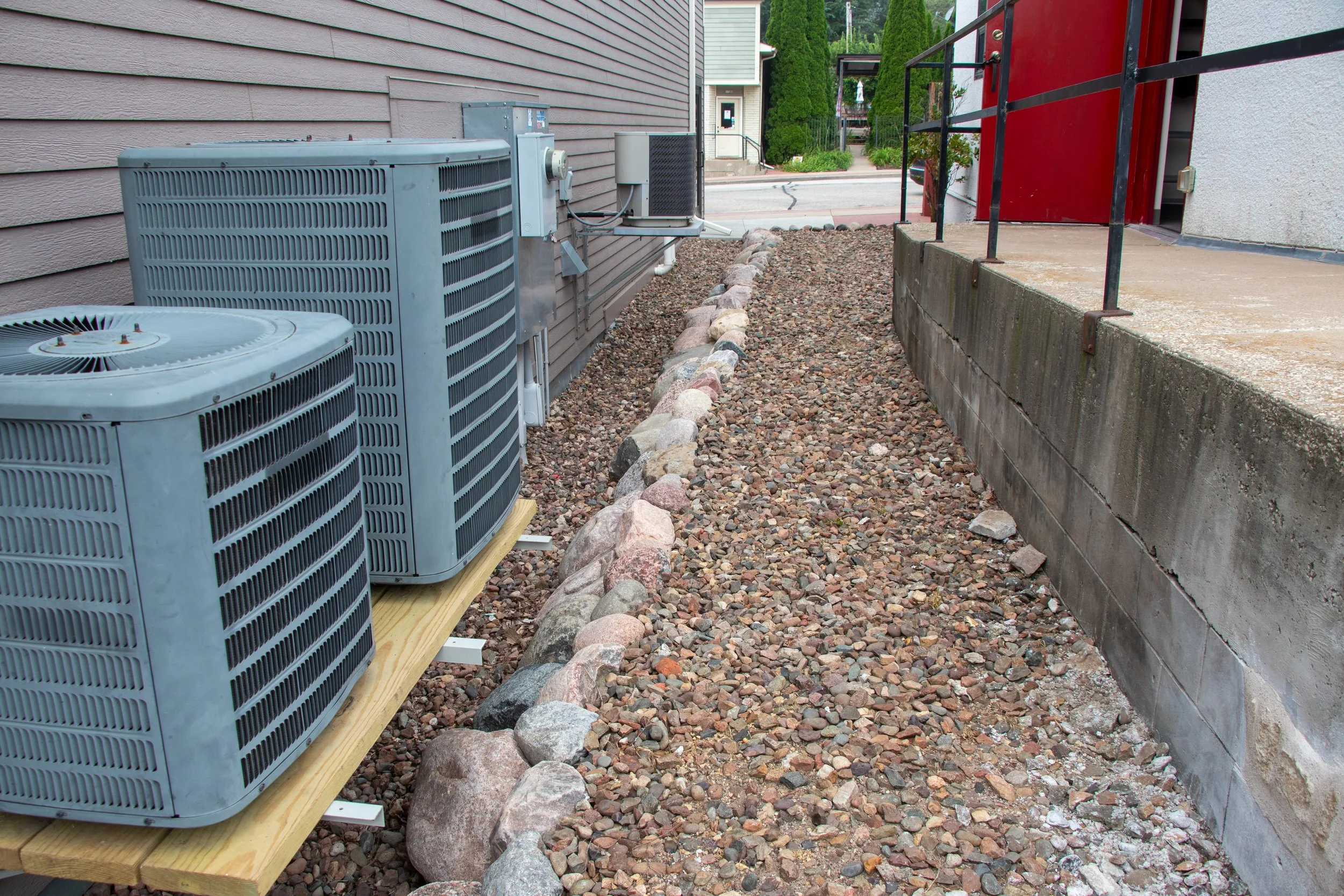 Stone-filled landscape bed with boulder edging along building wall
