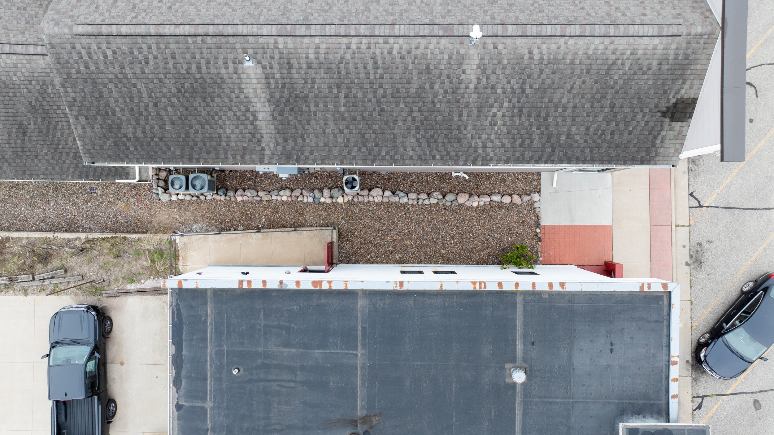 Top-down aerial view of stone-filled landscape bed along structure.