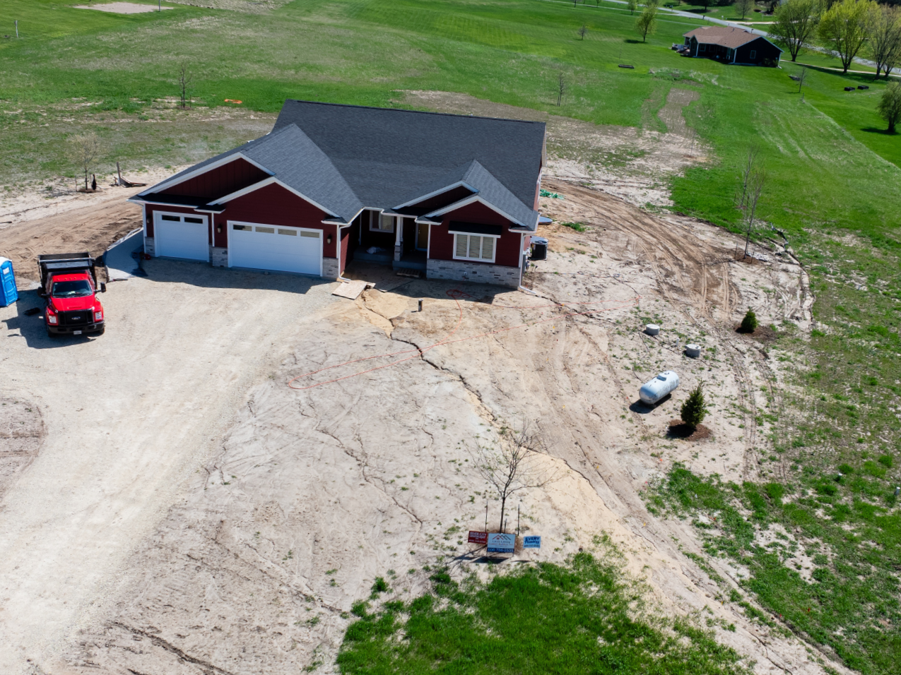Before landscape installation showing undeveloped yard and rough grading around home
