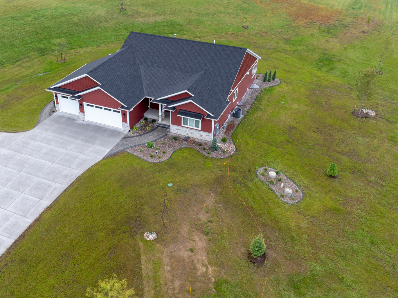 After landscape installation showing completed lawn, driveway, and established outdoor layout