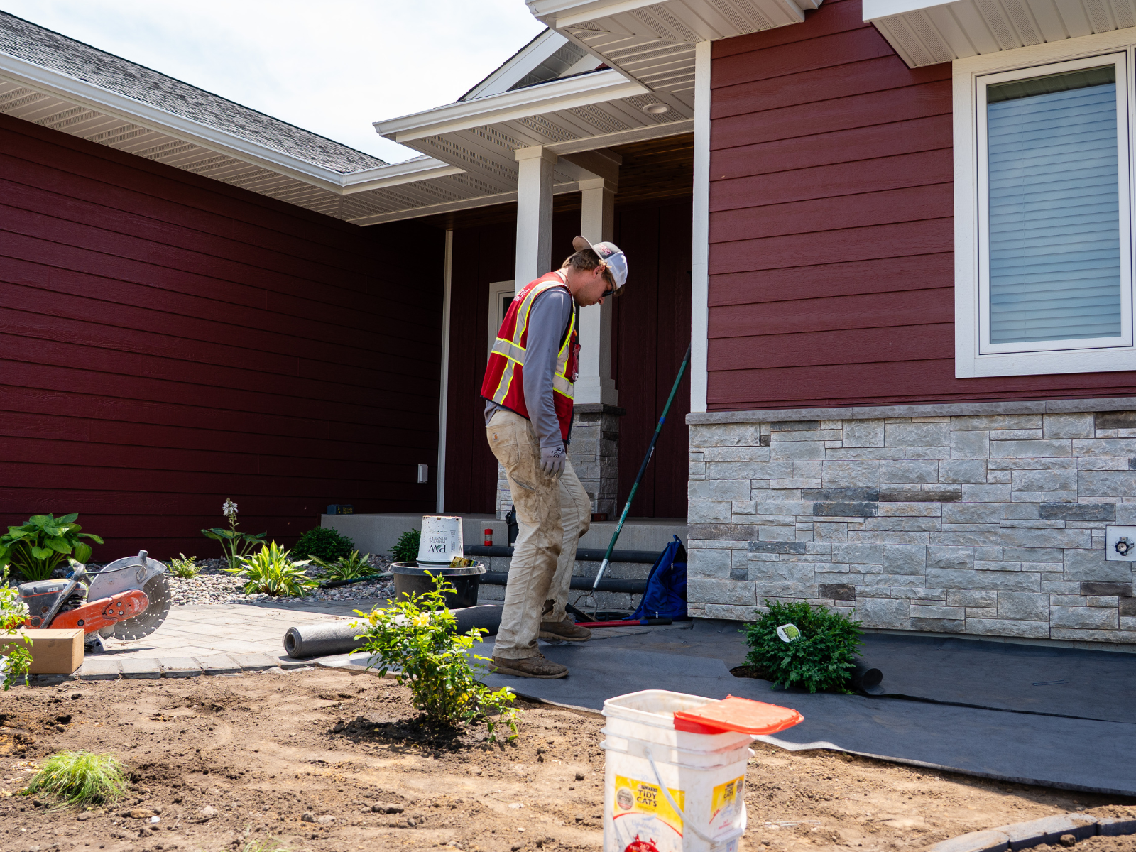  Landscape installation crew preparing planting beds along home exterior 