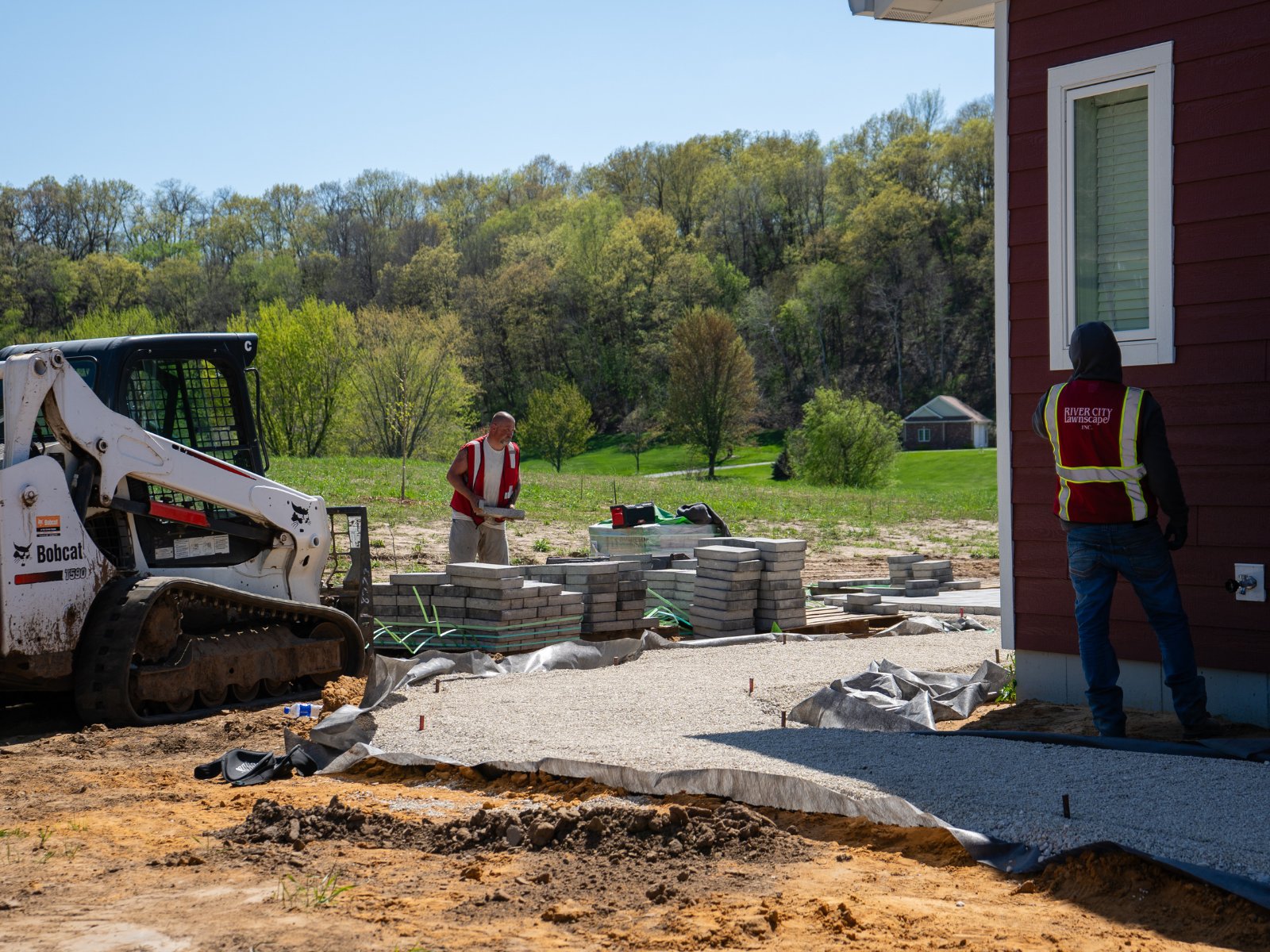  Landscape installation in progress with patio construction and site preparation 