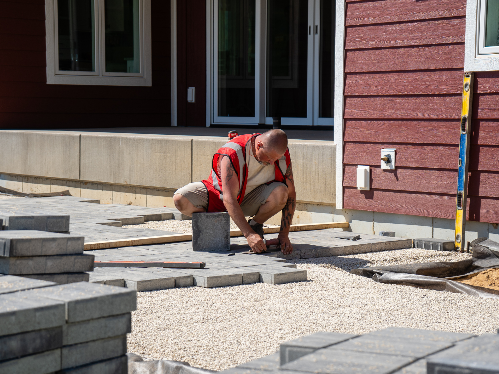  Crew setting patio pavers during hardscape installation 