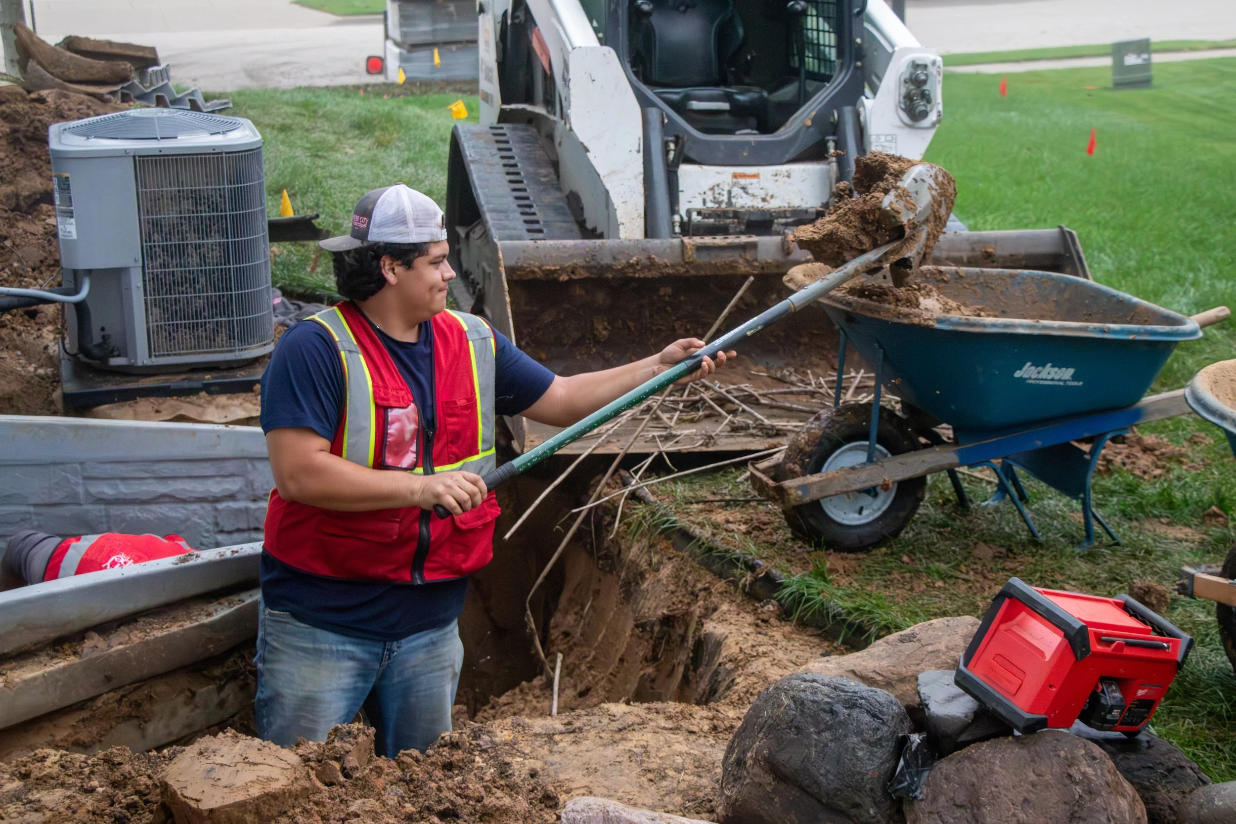  Crew shaping excavation around foundation wall 