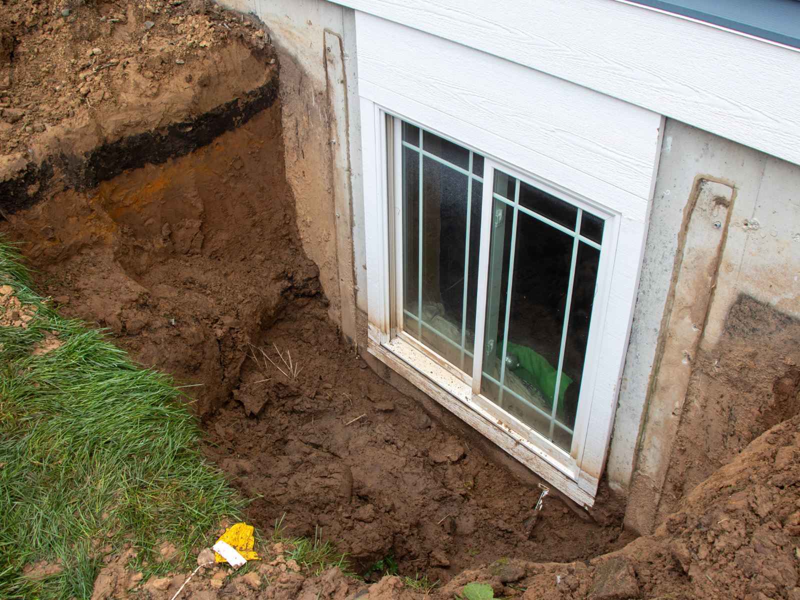  Exposed basement window during landscape excavation 