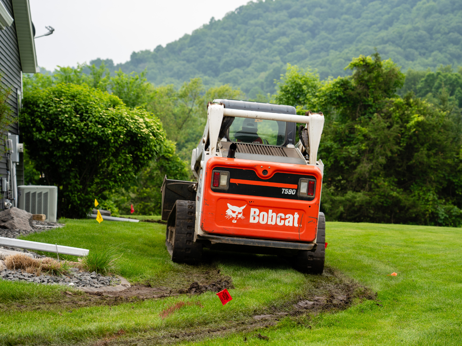 Equipment grading and preparing the site for hardscape installation.