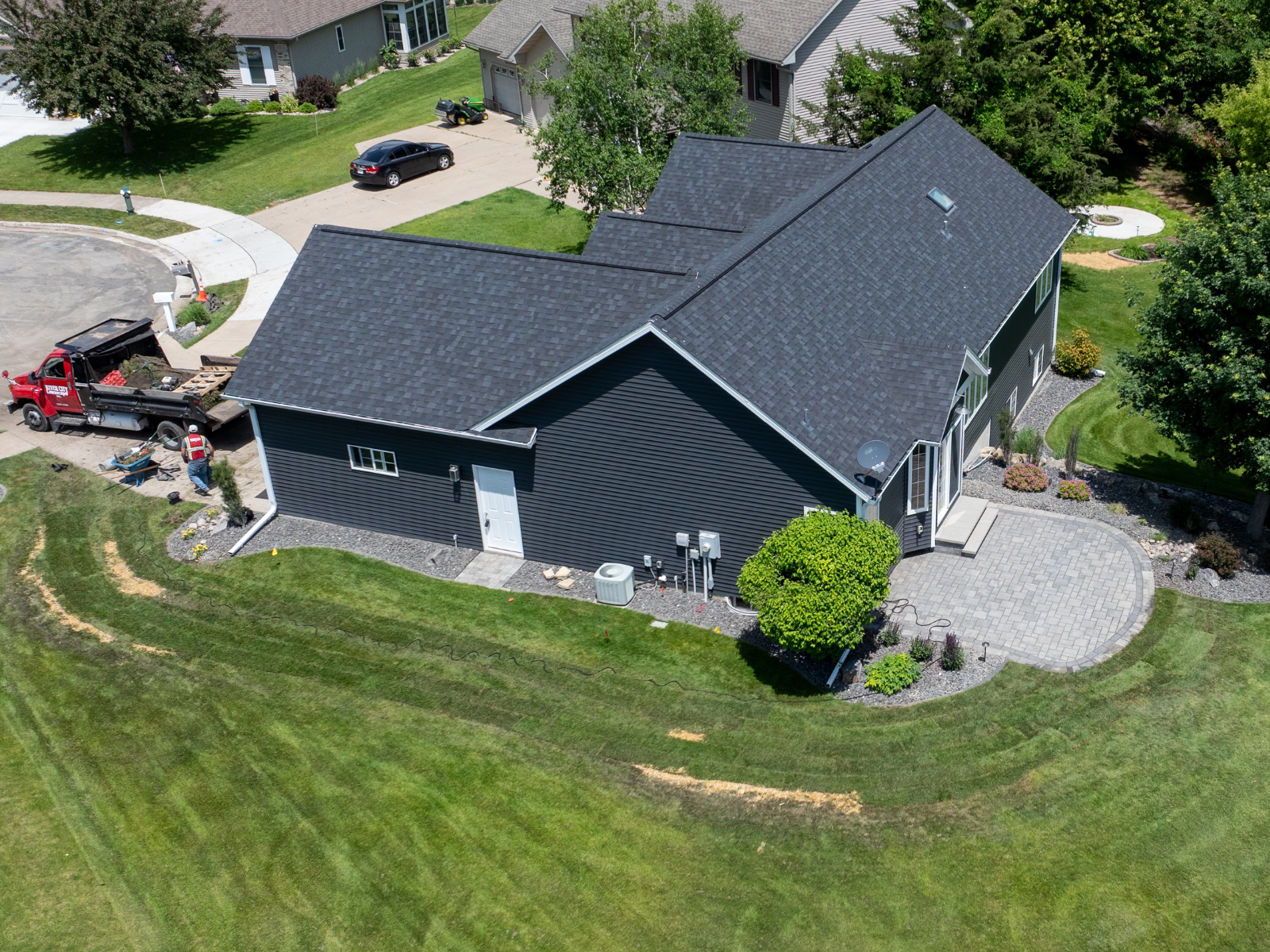 Aerial view showing patio layout and surrounding lawn during construction.