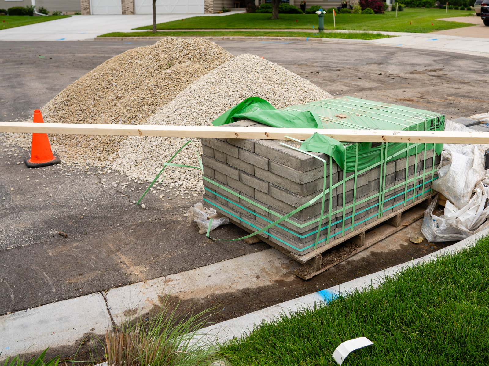 Stacked pavers and gravel staged on-site prior to patio installation.