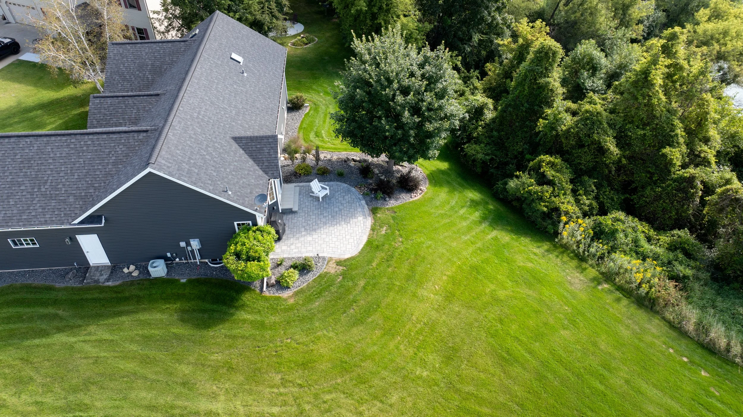 Aerial view showing patio integration with surrounding lawn and plantings.