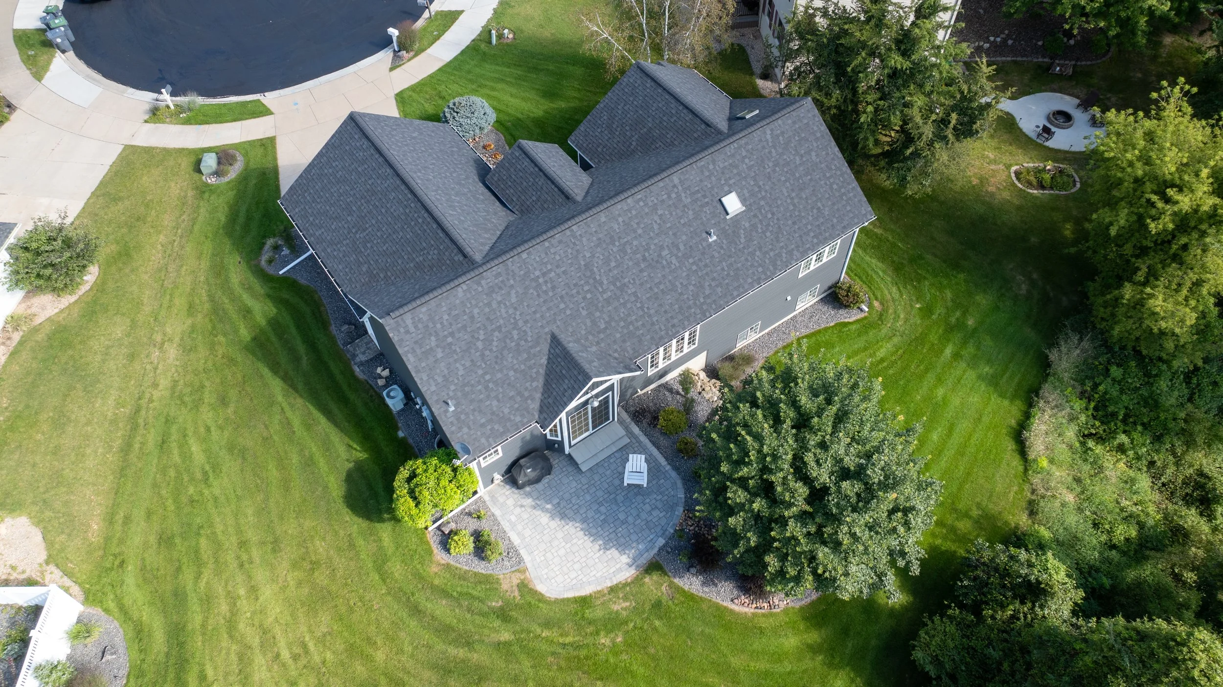 Top-down aerial view highlighting the finished patio behind the home.