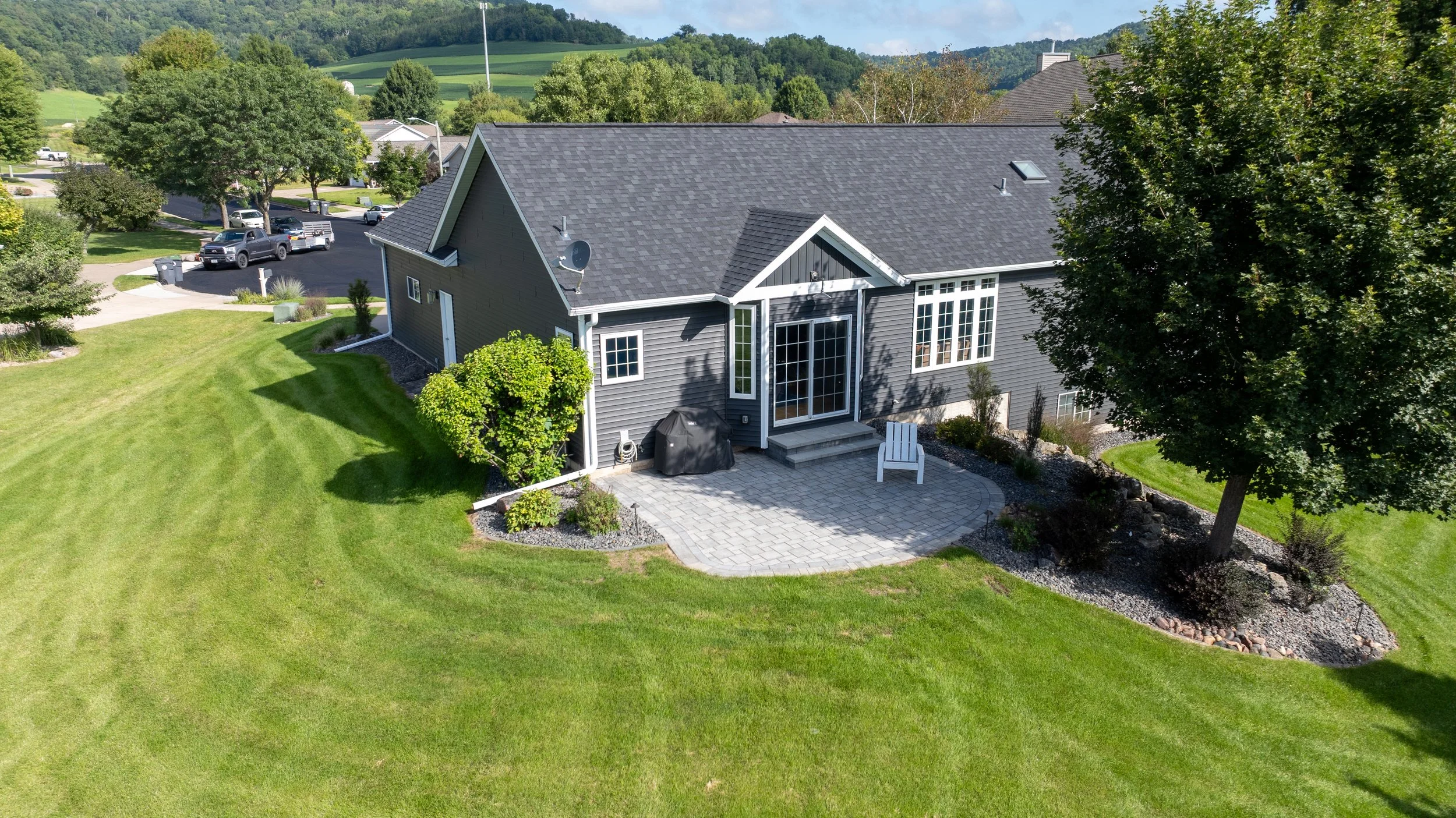 Front-facing aerial view of home with finished outdoor living space.