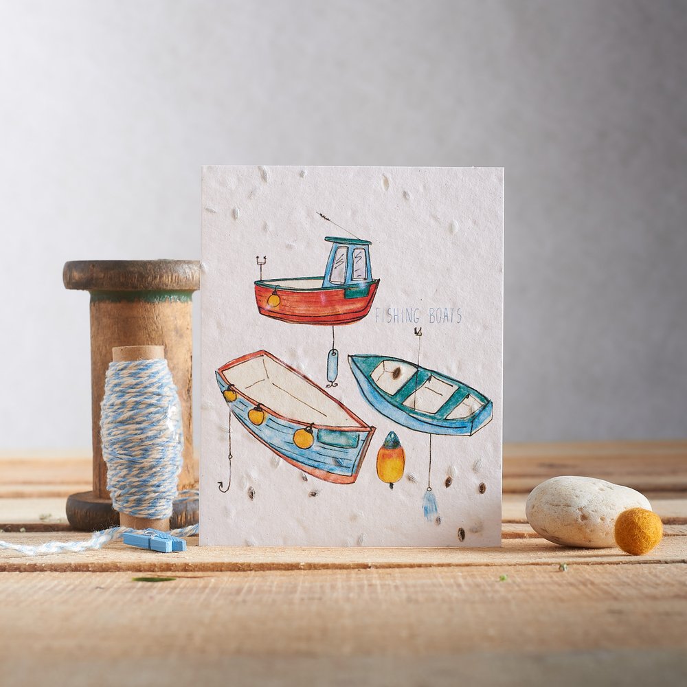  Seed embedded greeting card in nautical design photographed with nautical props on rustic planked surface 
