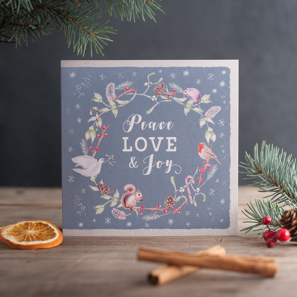  Peace, love and joy greeting card in Christmas setting with props 