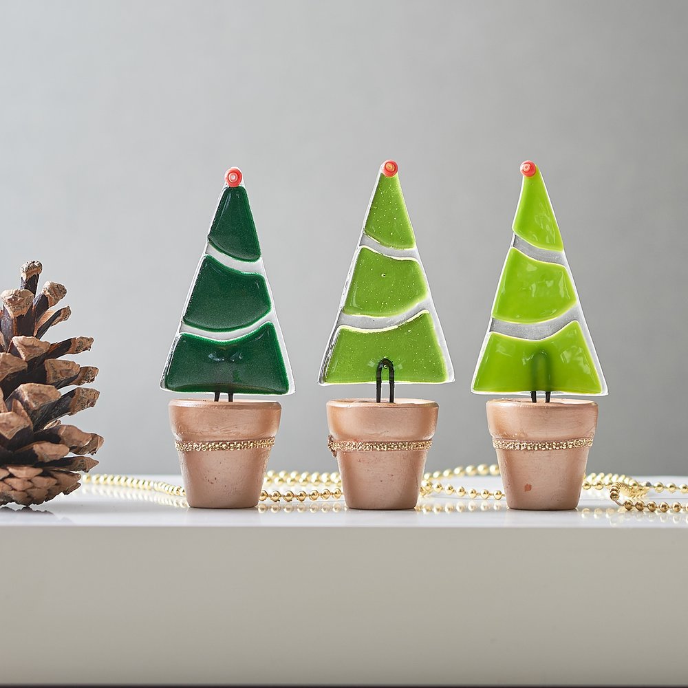  Small handmade glass Christmas trees in line up 