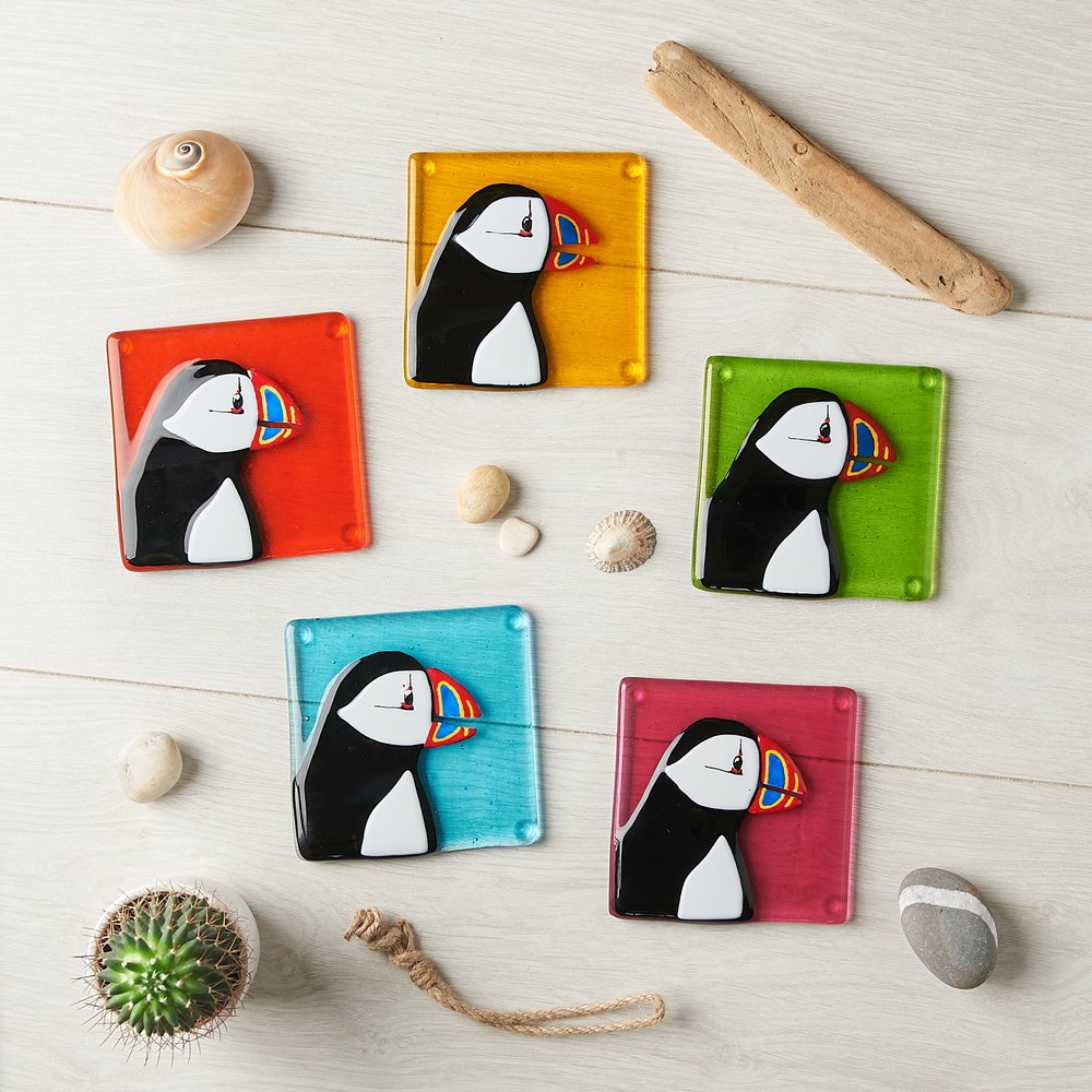  Puffin themed coasters in bright vivid coloured glass, photographed from above 