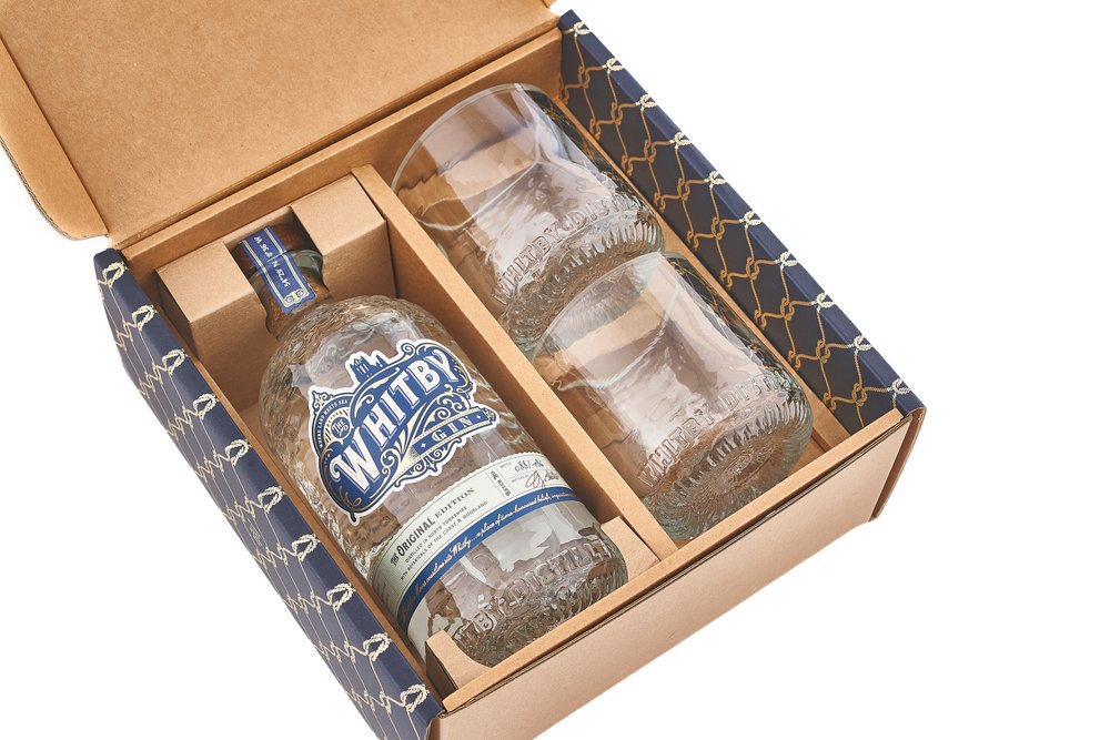  White background packshot of Whitby Gin bottle and two glasses in gift set box 