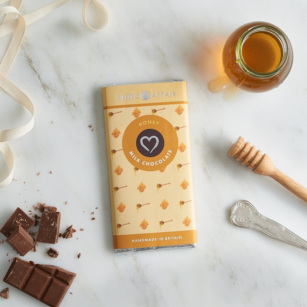  Honey flavour chocolate bar photographed with chocolate crumbs and honey pot 