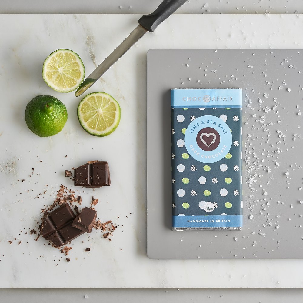  Sea salt and lime chocolate bar photographed from above with fresh lime and sea salt as props 