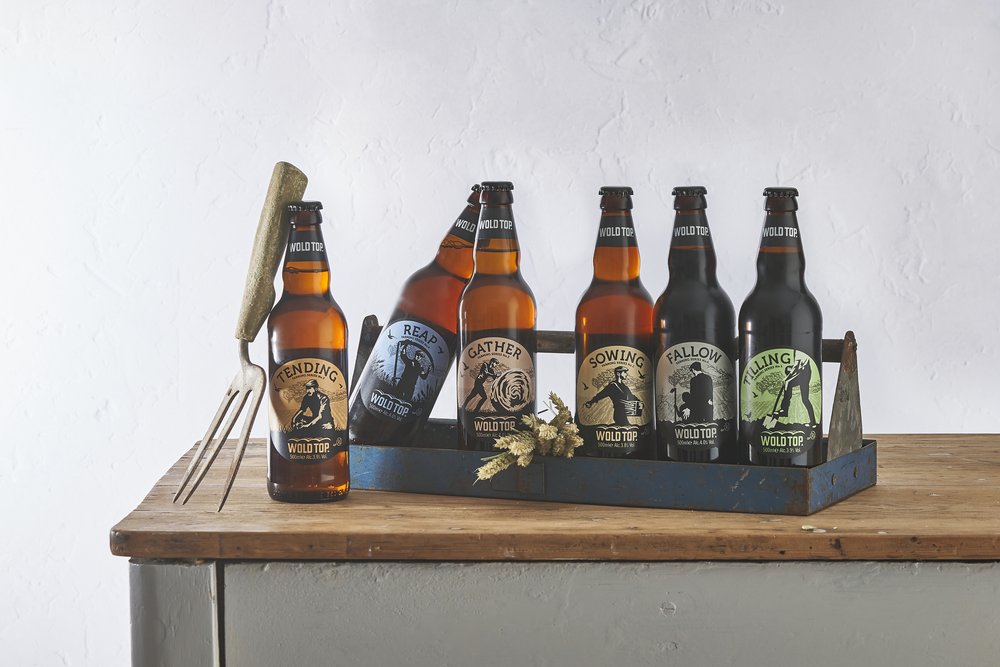  A group of six beers in bottles photographed on rustic table  