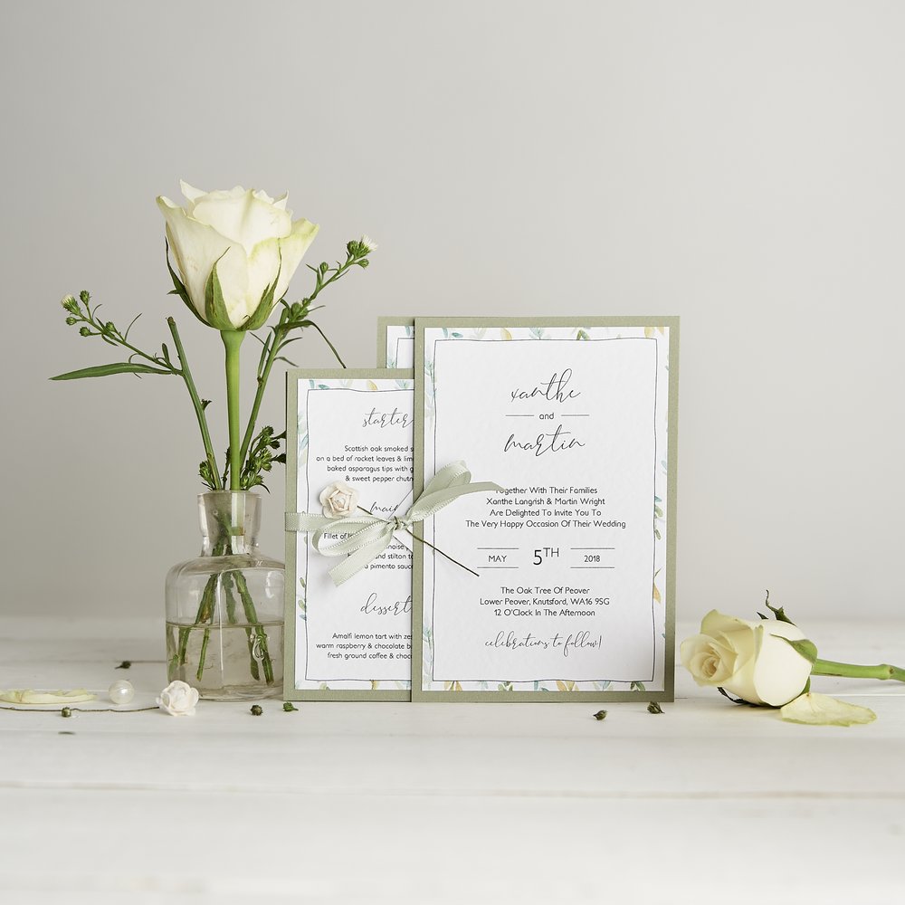  Wedding stationery invitations and detail card photographed next to fresh flower in small glass vase 3 