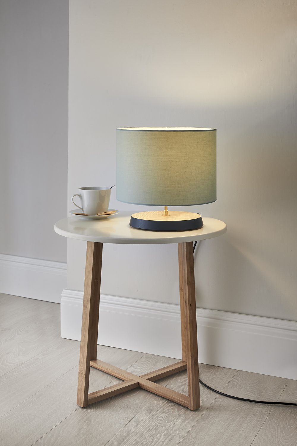  Image of lit handmade table lamp photographed upon modern side table  