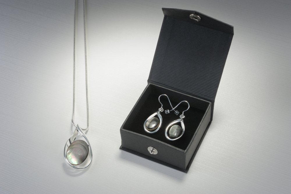  Earrings within black box and pendant necklace photographed in simple way  