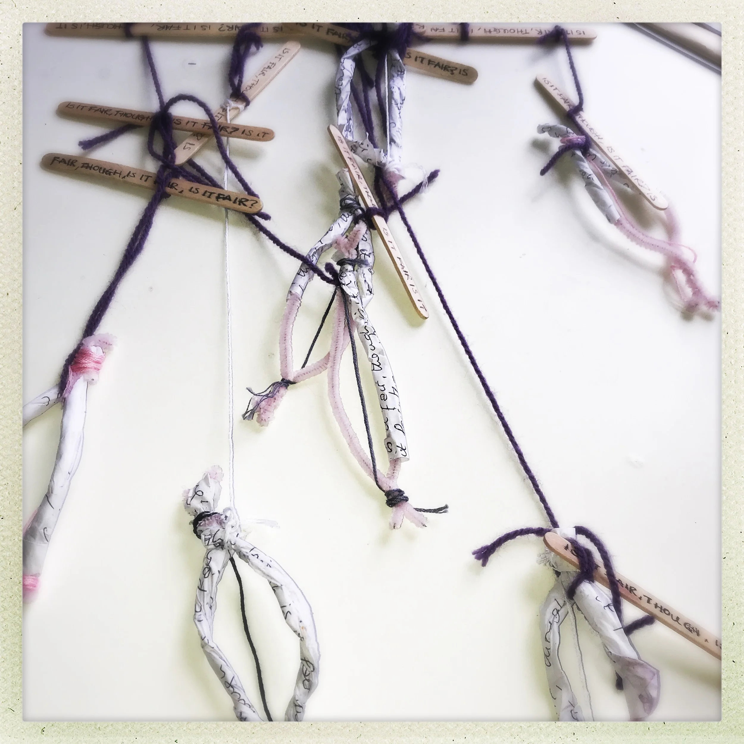 a mobile made from pipcleaners, lollipop sticks and string