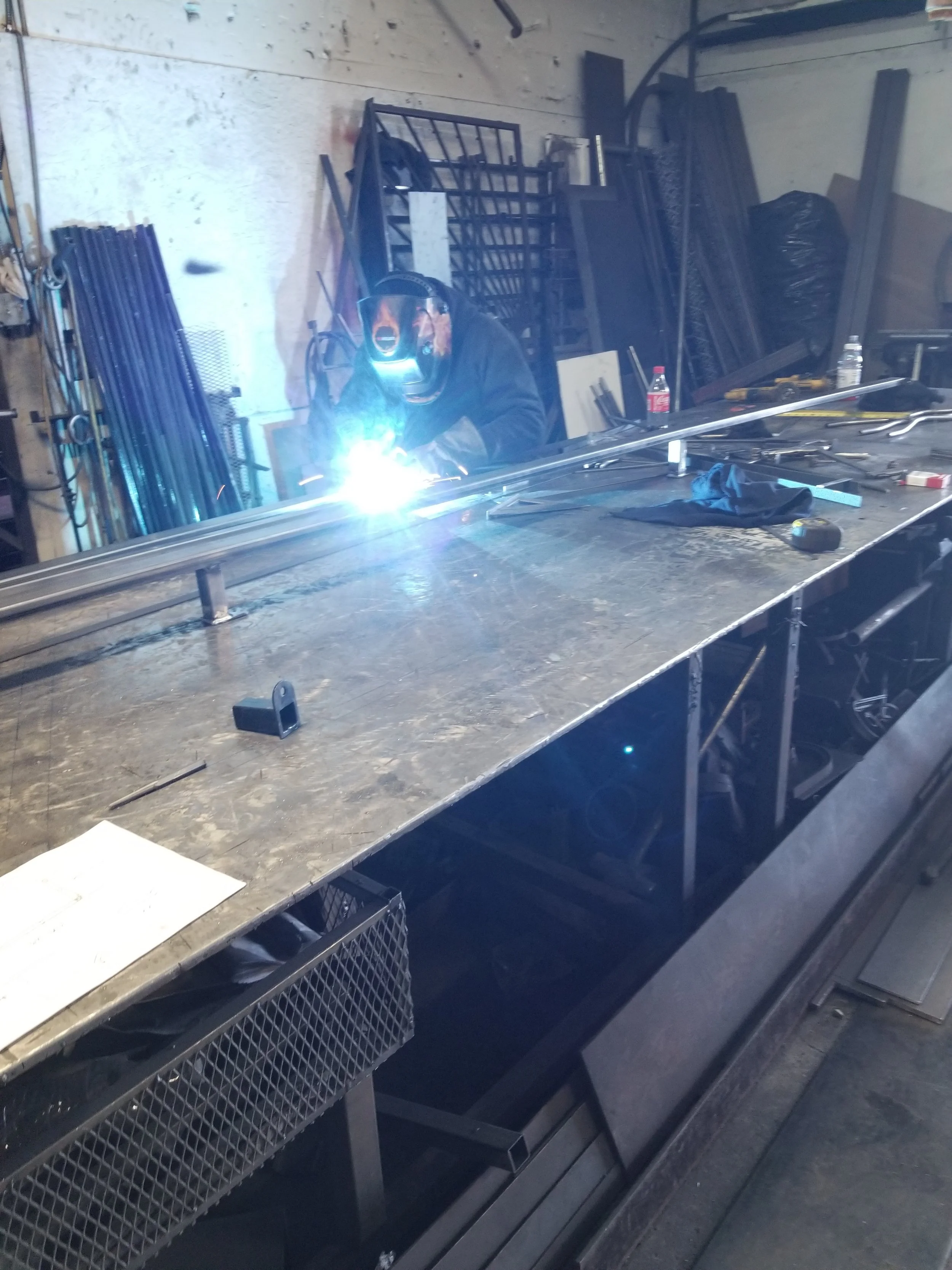 Expert welding an iron handrail in our warehouse.