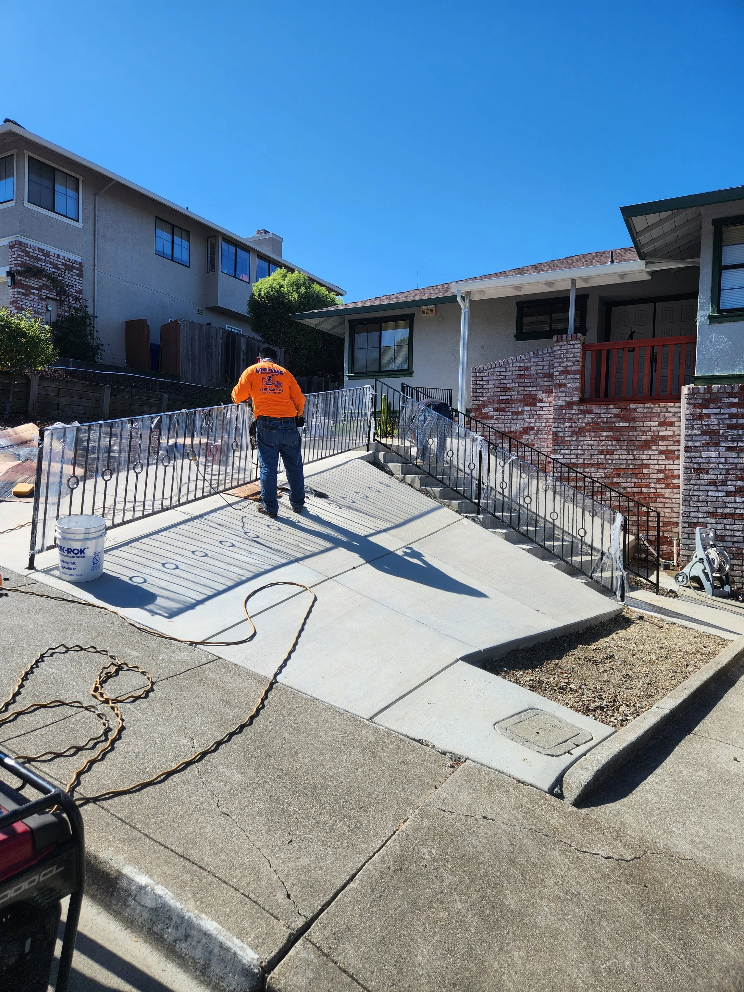 The iron professional is installing a black balcony over the terrace of a house for added security. 