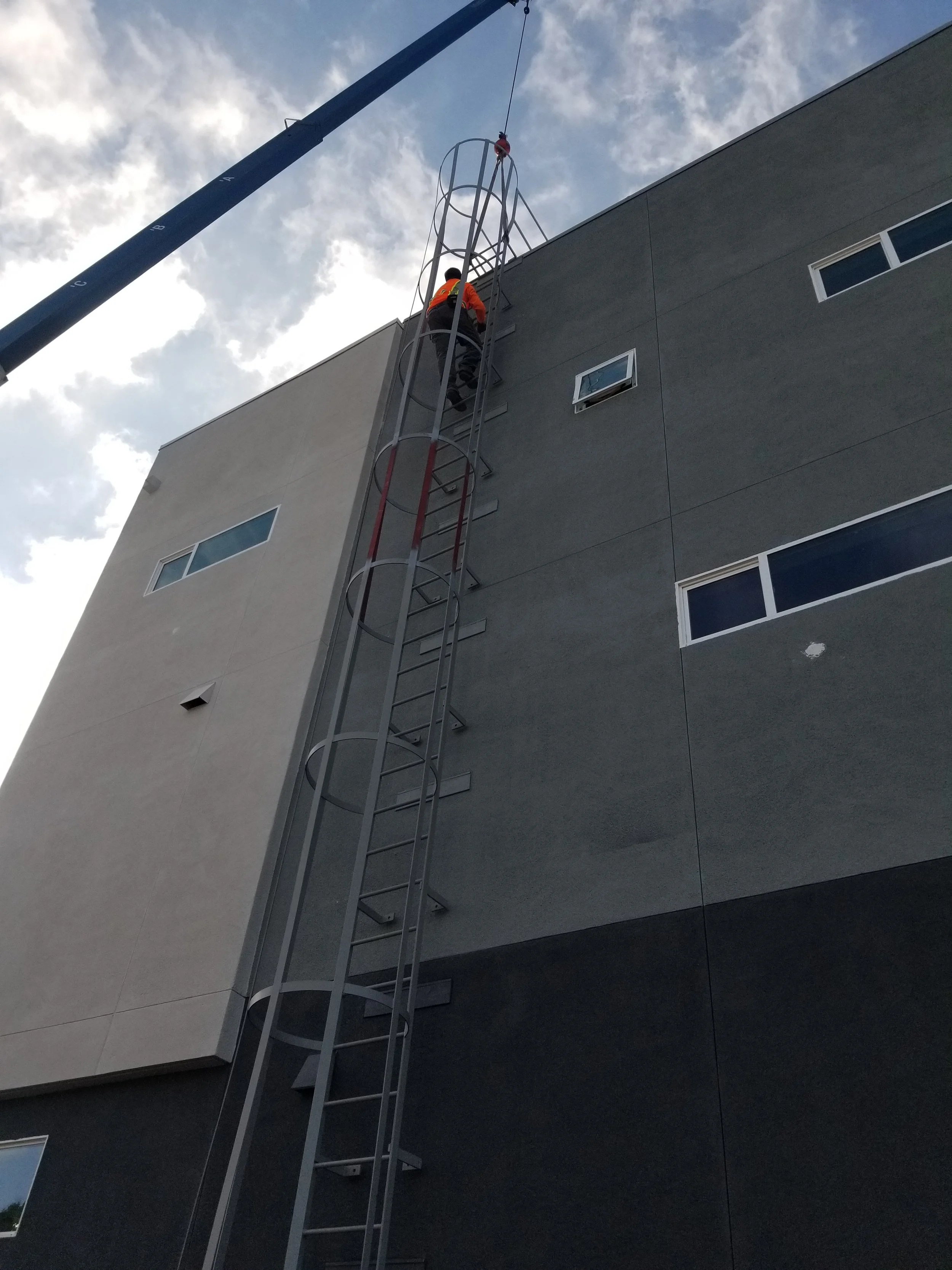 The installation of iron on the front of a tall, gray building in the northern regions of California.