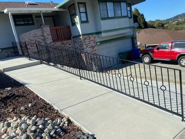 A black fence for the main entrance of a house with circular details made by the professional in iron. 