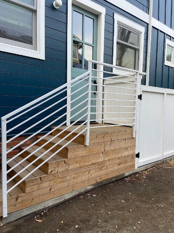 The expert in welding iron worked in a blue house and designed the elegant white handrail.