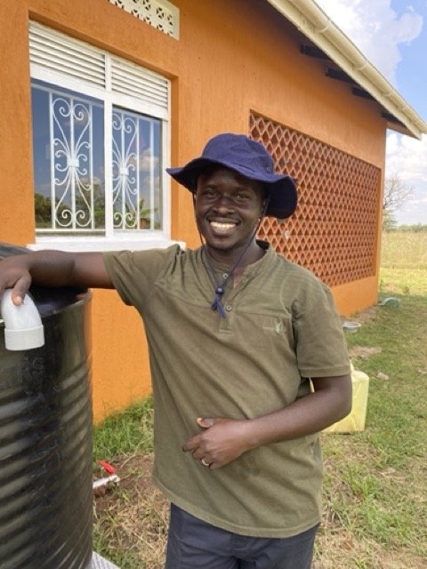 Clinic Staff Housing Richard, one of our lab technicians standing by a rain runoff tank.jpg
