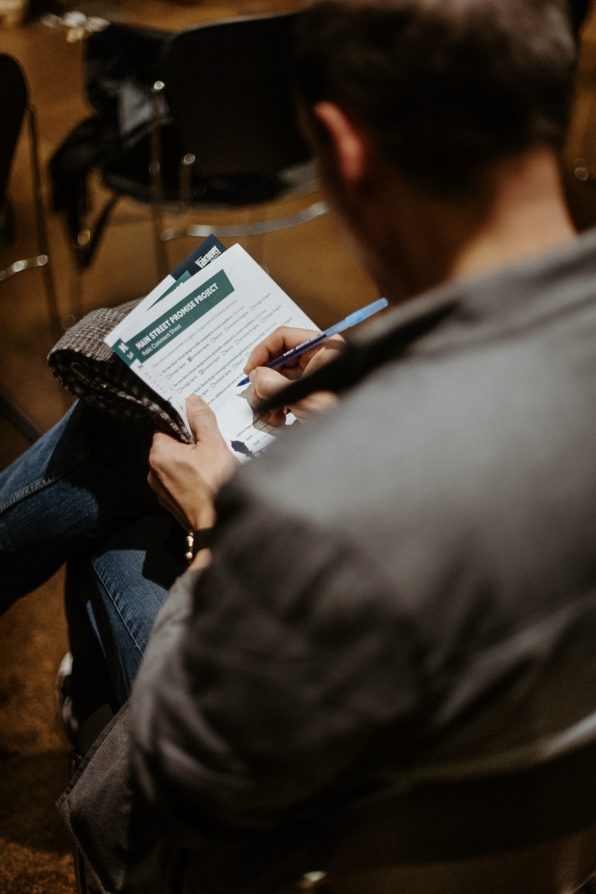 A person is writing on a survey