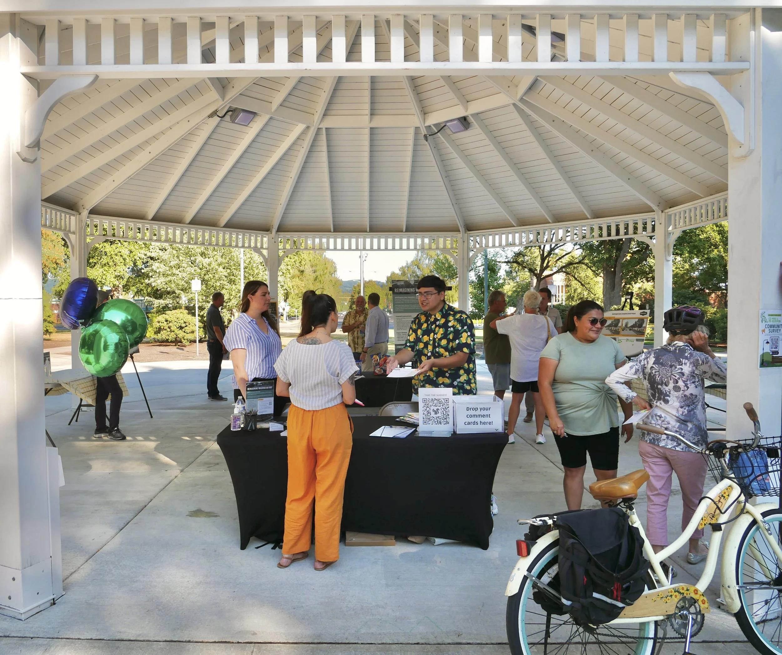 A group of people stand under a cover chatting at an open house