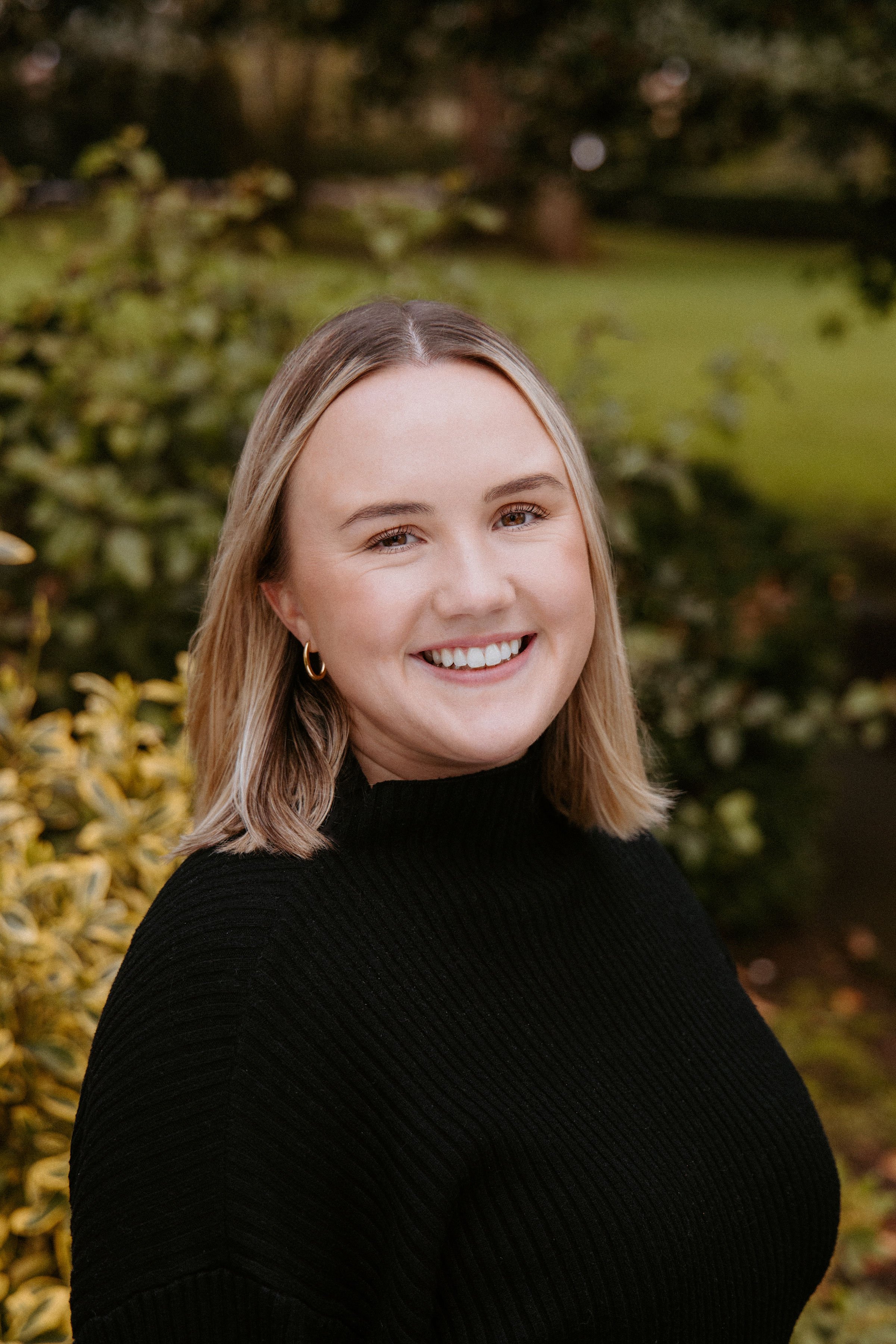 Photo of a woman with short blonde hair wearing a black sweater